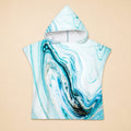 Poncho serviette a capuche motif marbre bleu ciel, posé à plat, montrant le devant du vêtement.