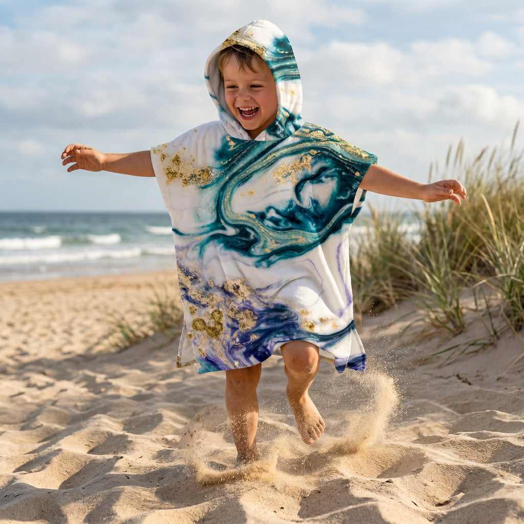 Poncho serviette a capuche motif marbre nuit dorée, porte par un garcon courant et sautant sur la plage.