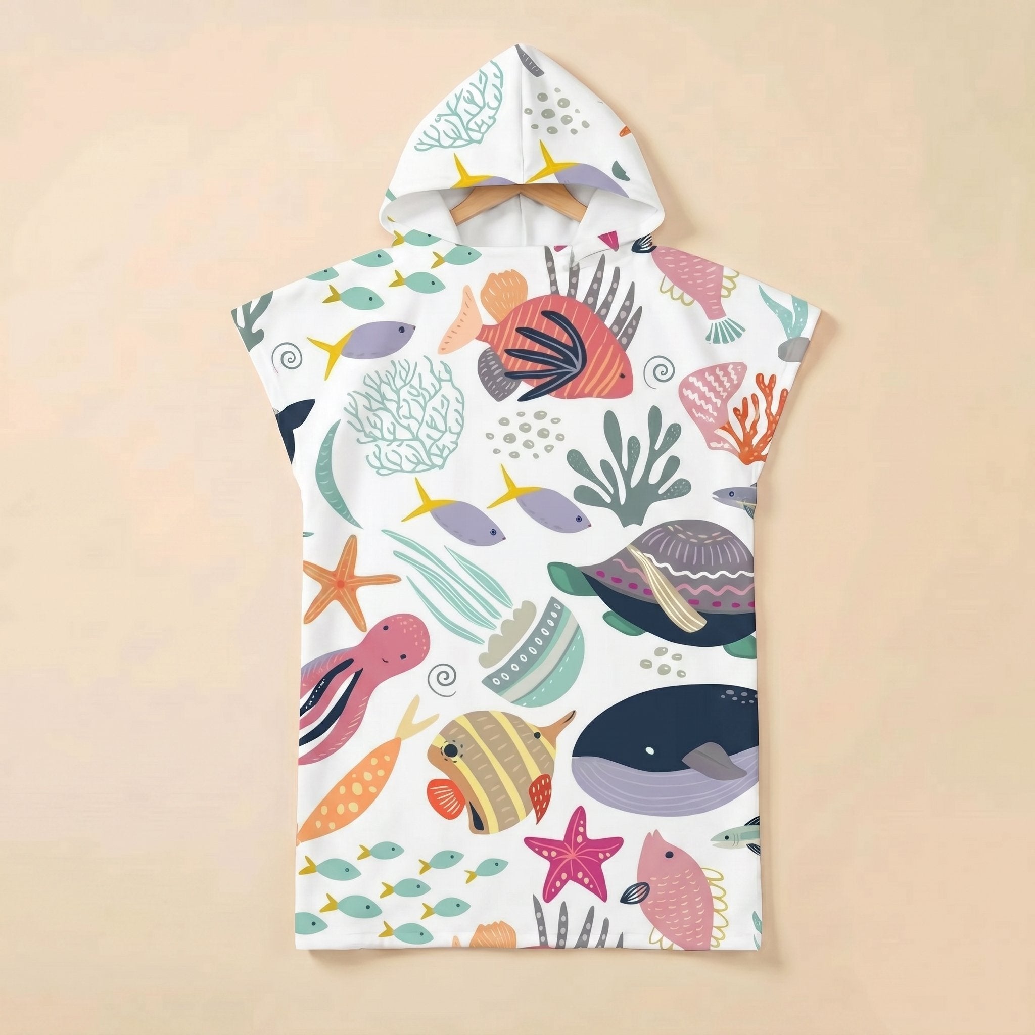 Poncho serviette a capuche motif Fonds marins colorés, posé à plat sur un fond uni.