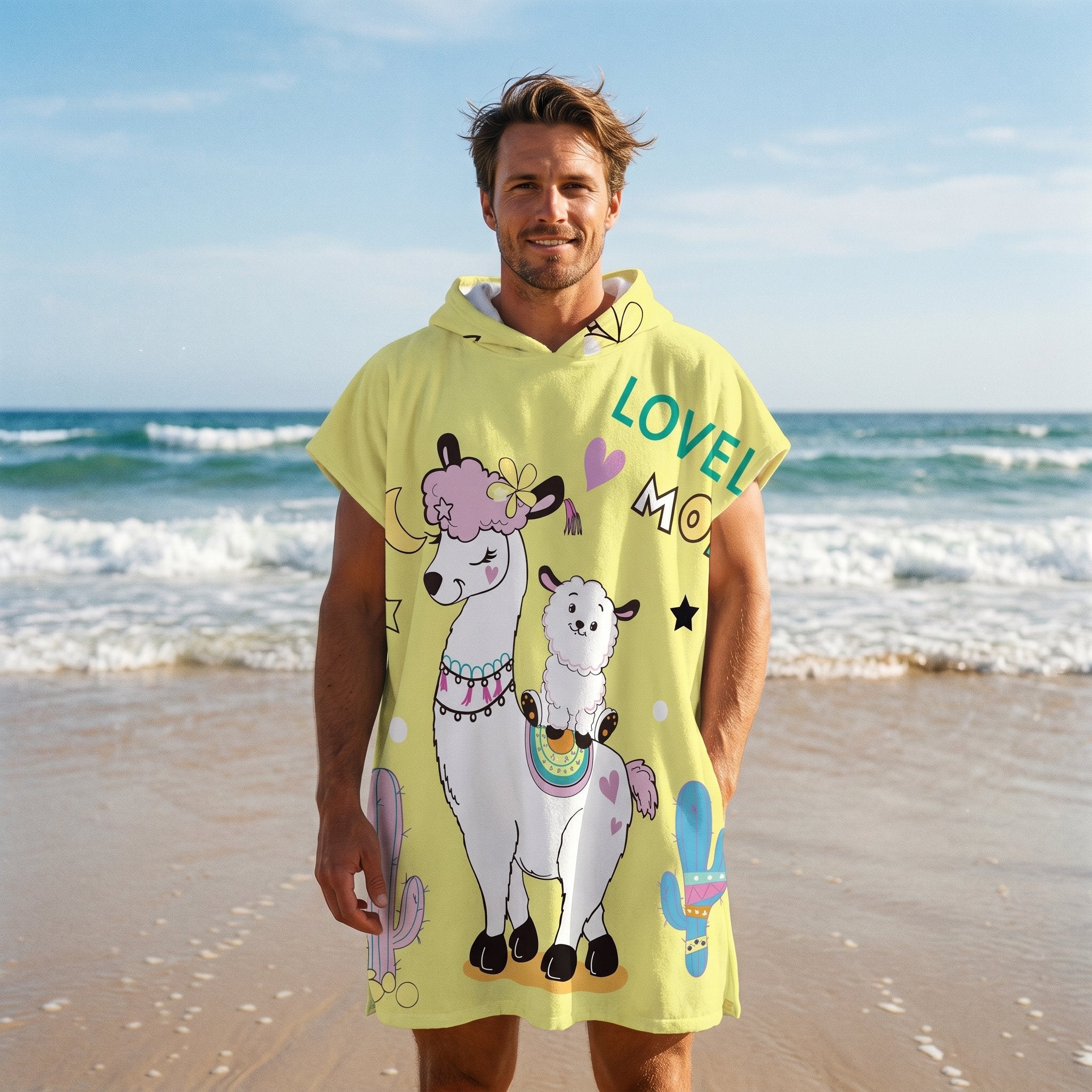 Poncho serviette à capuche motif lamas et cactus, porté par un homme souriant sur une plage, regardant l'objectif.
