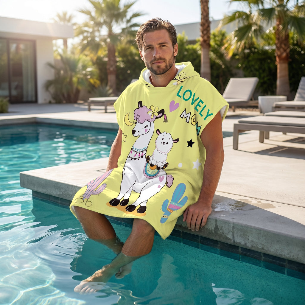 Poncho serviette à capuche motif lamas et cactus, porté par un homme au bord d'une piscine, les pieds dans l'eau.