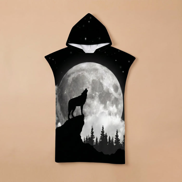 Poncho serviette à capuche motif loup hurlant, posé à plat sur un fond uni beige, montrant le motif en entier.