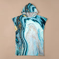 Poncho serviette à capuche motif marbre turquoise doré, posé à plat et vu de face.
