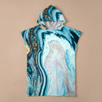 Poncho serviette à capuche motif marbre turquoise doré, posé à plat et vu de face.