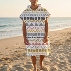 Poncho serviette à capuche motif zigzags graphiques porté par un homme debout sur le sable, regardant vers l'avant.