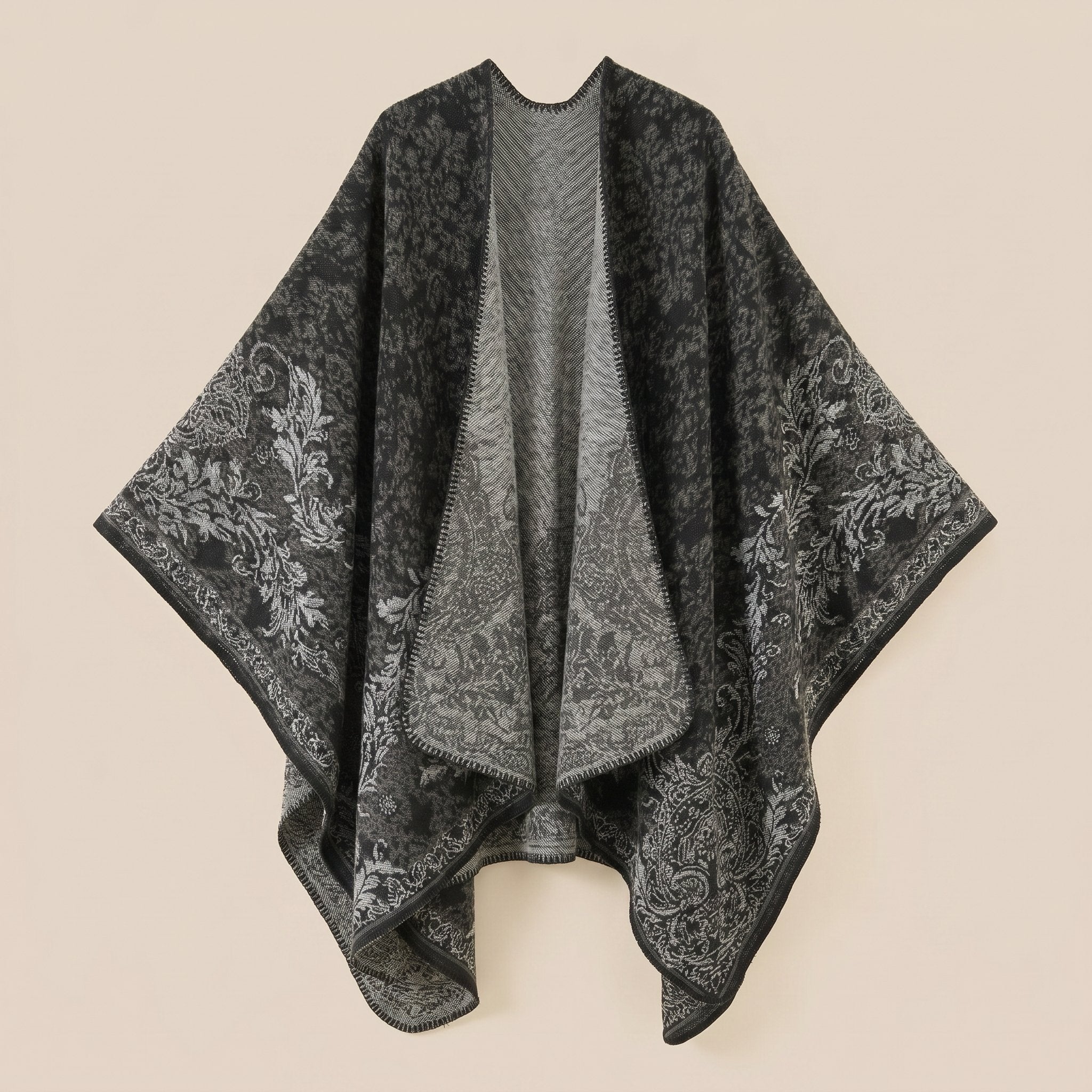 Poncho tricot femme, cape ouverte à motif paisley noir et gris, présentée à plat, motifs détaillés