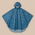 Poncho vélo motif fleurs bleu nuit, posé à plat sur un fond uni, vue de face.