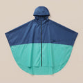 Poncho vélo marine et vert d'eau, présenté à plat sur un fond uni, montrant sa coupe ample.