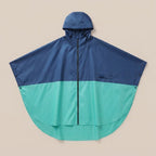 Poncho vélo marine et vert d'eau, présenté à plat sur un fond uni, montrant sa coupe ample.