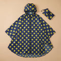Poncho vélo motif pois moutarde bleu marine et jaune, présenté à plat avec sa pochette de rangement.