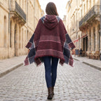 Pull poncho à capuche femme à carreaux, porté de dos par une femme marchant, mettant en évidence les motifs et les franges