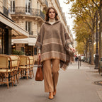 Pull poncho à capuche femme rayé taupe, porté de face par une femme marchant en extérieur, montrant le col